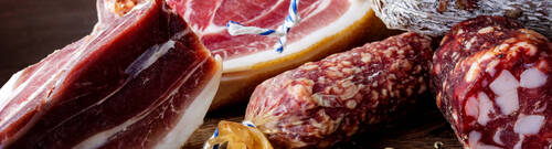 Traditional sausage , sausage with mold and spanish ham( bellota, jamon). Sliced sausage salami on wooden board with spices: pepper and fennel. Close-up.